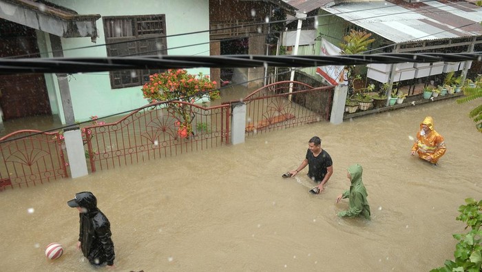 BANJIR DI MANADO Anggota TNI menggendong seorang anak yang dievakuasi dari rumahnya yang terendam banjir di Manado, Sulawesi Utara, Jumat (27/1/2023). Hujan deras sejak dini hari mengakibatkan banjir dan longsor di sejumlah lokasi di kota Manado. ANTARA FOTO/Adwit B Pramono/foc.
