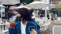 Begitu pun dengan momen yang satu ini. Ia menikmati minuman favoritnya saat di kafe yang ada di luar negeri. Kafenya unik bernuansa putih. Foto: Instagram @enzystoria
