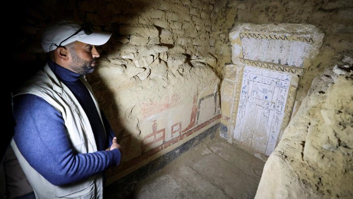 Ini Makam Berusia 4.300 Tahun yang Baru Ditemukan di Mesir A women takes a selfie after the announcement of the discovery of 4,300-year-old sealed tombs, which have made a number of important archaeological discoveries dating to the fifth and sixth dynasties of the Old Kingdom, also stated that the expedition had found a group of Old Kingdom tombs, indicating that the site comprised a large cemetery, where the most important tomb belonged to Khnumdjedef, an inspector of the officials, a supervisor of the nobles, and a priest in the pyramid complex of Unas, the last kind of the fifth dynasty, in Egypt's Saqqara necropolis, in Giza, Egypt, January 26, 2023. REUTERS/Mohamed Abd El Ghany
