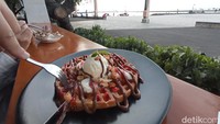 Ada waffle choco banana yang renyah dengan saos stoberi dan kacang. Porsinya lumayan dan harganya Rp 45 ribu saja. Cocok untuk ngemil menikmati sunset. Foto: Bonauli/detikcom