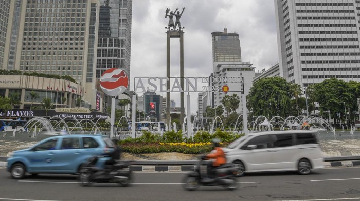 Pengendara motor melintas di depan logo KTT ASEAN Summit 2023 di Bundaran HI, Jakarta, Jumat (27/1/2023). Indonesia akan menjadi tuan rumah bagi perhelatan KTT ASEAN Summit 2023, pertemuan tersebut akan dilaksanakan pada bulan Mei mendatang di Labuan Bajo, Nusa Tenggara Timur, (NTT).