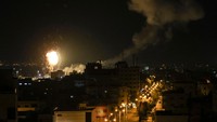 Api dan asap mengepul di atas gedung-gedung Kota Gaza, Palestina, Jumat (27/1/2023). (Mahmud Hams/AFP via Getty Images)  