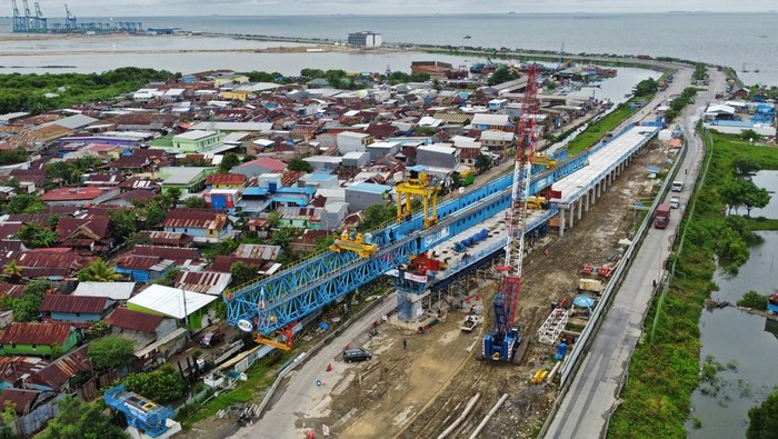 Foto udara pembangunan proyek jalan tol Makassar New Port, di Makassar, Sulawesi Selatan, Kamis (26/1/2023). Proyek jalan tol sepanjang 3,2 kilometer dengan nilai investasi Rp705 miliar tersebut ditargetkan beroperasi pada Juni 2023 untuk mendukung operasional Makassar New Port . ANTARA FOTO/Arnas Padda/hp.