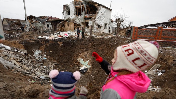 Employees of power supplier repair power lines in front of residential houses damaged by a Russian military strike, amid Russia's attack on Ukraine, in the town of Hlevakha, outside Kyiv, Ukraine January 26, 2023.  REUTERS/Valentyn Ogirenko