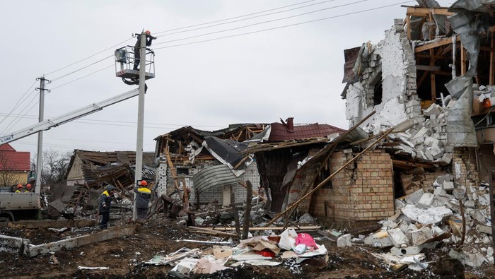 Permukiman Warga di Hlevakha Ukraina Hancur Lebur Dirudal Rusia Employees of power supplier repair power lines in front of residential houses damaged by a Russian military strike, amid Russia's attack on Ukraine, in the town of Hlevakha, outside Kyiv, Ukraine January 26, 2023. REUTERS/Valentyn Ogirenko