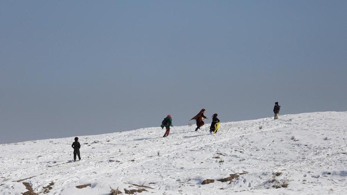 Afghan children play with each other on the snow-covered ground in Kabul, Afghanistan, January 26, 2023. REUTERS/Ali Khara