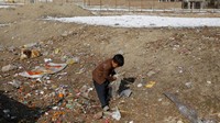 Seorang anak mengumpulkan plastik untuk dibakar di tengah musim dingin di Kabul, Afghanistan, 26 Januari 2023.