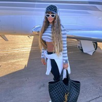 Begitu juga dengan gaya fashionnya yang menggunakan barang-barang dari brand kelas atas. Berpose di depan private jet-nya, Rafella menenteng tas YSL. Foto: dok. Instagram
