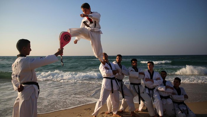 Palestinian youths show their skills and practice taekwondo on the Mediterranean beach during sunset in Khan Yunis, southern Gaza Strip. The ''Funoon'' taekwondo team trains taekwondo at the Mediterranean beach, as part of a training program organized by the trainers in the team, as they allocate a day of training on the seashore of Khan Yunis, southern Gaza Strip, on January 25, 2023.  (Photo by Majdi Fathi/NurPhoto via Getty Images)