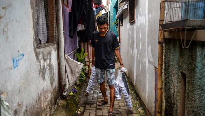 Sentra Sepatu Legendaris Cibaduyut yang Semakin Meredup Perajin membawa bahan untuk produksi alas kaki di Kawasan Sentra Sepatu Cibaduyut, Bandung, Jawa Barat, Jumat (27/1/2023). Dinas Perindustrian dan Perdagangan Jawa Barat mencatat, jumlah perajin di Sentra Sepatu Cibaduyut kini hanya tersisa 50 orang perajin, hal tersebut dikarenakan masalah regenerasi yang membuat sentra sepatu legendaris tersebut meredup.