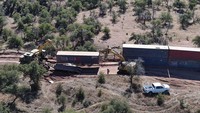 Tembok panjang yang membentang melintasi lanskap Arizona ini bukanlah dinding atau pagar biasa, tetapi dibuat dari kontainer yang ditumpuk satu sama lain.  