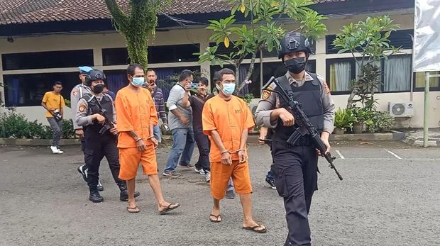 Dua pelaku persetubuhan anak dibawah umur saat digiring oleh petugas kepolisian di halaman Polres Jembrana, Sabtu (28/1/2023). (I Putu Adi Budiastrawan/detikBali).