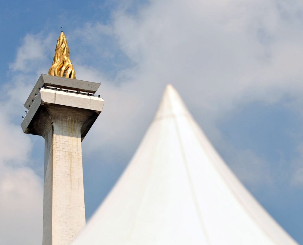 Sebuah gambar memperlihatkan Monumen Nasional atau Monas (kiri) dengan api berlapis emas melambangkan perjuangan kemerdekaan Indonesia berdiri setinggi 422 kaki di Jakarta pada tanggal 26/2/2010. AFP PHOTO / ADEK BERRY via Getty Images/File