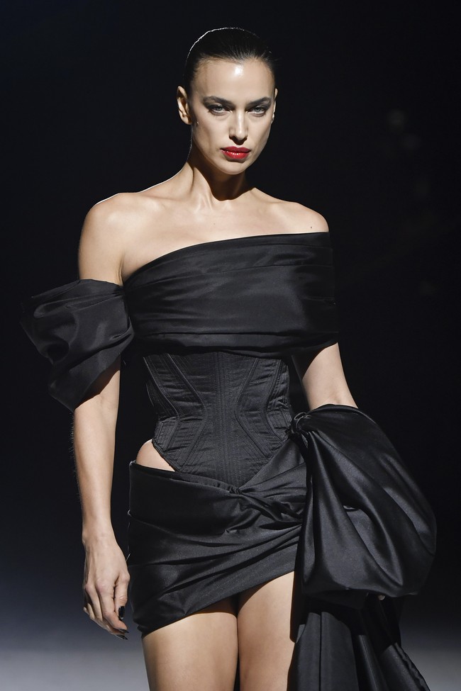 Gaun yang dipakai model 37 tahun itu hadir dengan atasan bergaya off-shoulder yang mengekspos bahu, berikut korset yang mempertegas lekuk tubuhnya. Tidak ketinggalan rok mini dengan ekor yang menyembul dramatis hingga menyapu lantai. (Foto: Stephane Cardinale/Corbis via Getty Images)