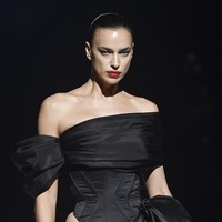 Gaun yang dipakai model 37 tahun itu hadir dengan atasan bergaya off-shoulder yang mengekspos bahu, berikut korset yang mempertegas lekuk tubuhnya. Tidak ketinggalan rok mini dengan ekor yang menyembul dramatis hingga menyapu lantai. (Foto: Stephane Cardinale/Corbis via Getty Images)