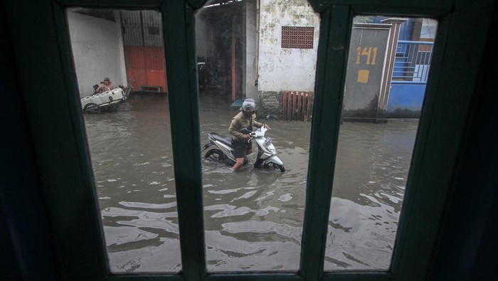 BANJIR DI SIDOARJO Pengendara melintasi jalan yang tergenang air di Desa Kureksari, Waru, Sidoarjo, Jawa Timur, Minggu (29/1/2023). Curah hujan tinggi dan daya tampung sungai yang belum memadai serta drainase yang buruk mengakibatkan air menggenangi ruas jalan dan kawasan pemukiman warga. ANTARA FOTO/Umarul Faruq/nym.