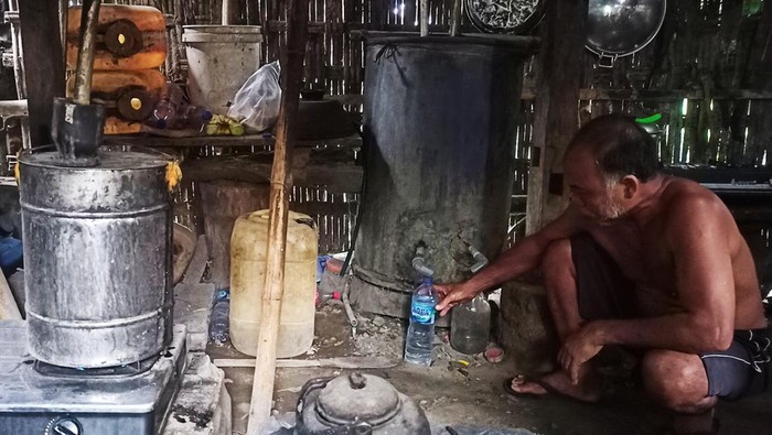 I Wayan Kasih, perajin arak tradisional di Merita, Desa Labasari, Kecamatan Abang, Karangasem, saat melakukan proses pembuatan arak Bali, Jumat (27/1/2023). (Foto: I Wayan Selamat Juniasa/detikBali)