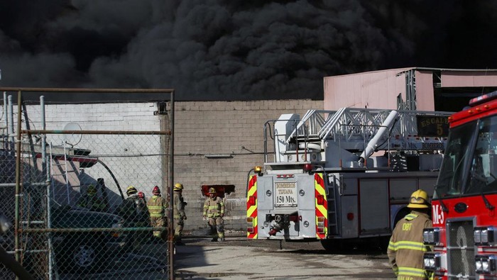 Firefighters work to extinguish a fire at the Otay industrial zone near the U.S.-Mexico border, in Tijuana, Mexico January 28, 2023. REUTERS/Jorge Duenes