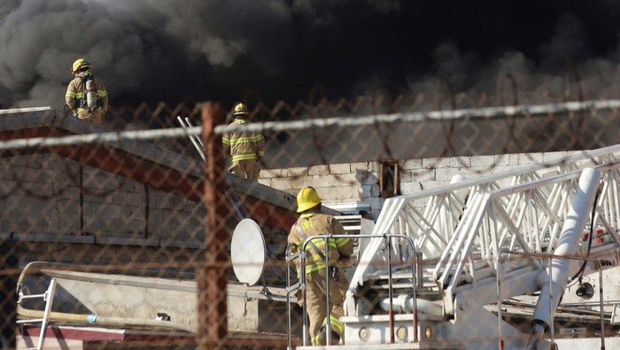 Firefighters work to extinguish a fire at the Otay industrial zone near the U.S.-Mexico border, in Tijuana, Mexico January 28, 2023. REUTERS/Jorge Duenes