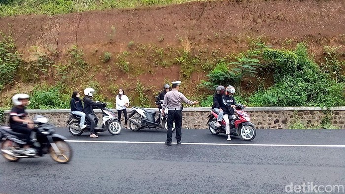 Para pemotor berusaha menghindari polisi di Jalan Baru Lingkar Timur, Kuningan, Minggu (29/1/2023).