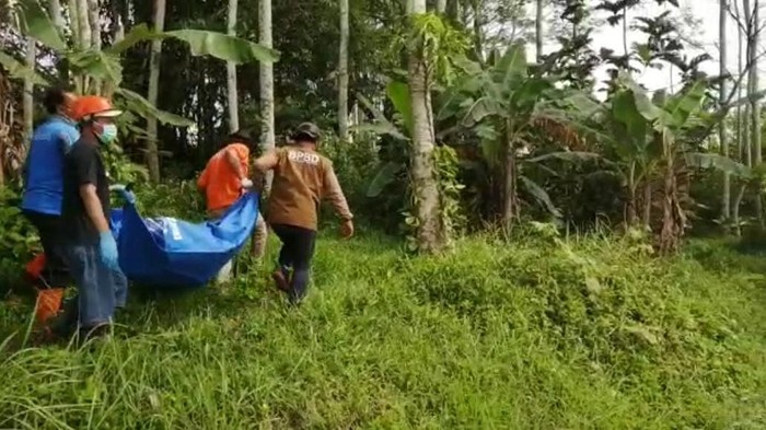 Petugas saat mengevakuasi jenazah bocah yang hilang di Malang