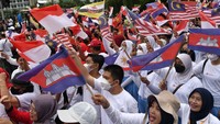 Warga tampak mengibarkan bendera negara anggota ASEAN.