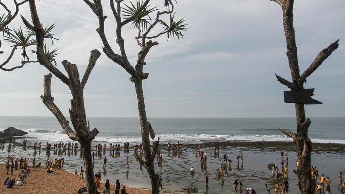 Pengunjung bermain air di Pantai Kukup, Tanjungsari, Gunungkidul, DI Yogyakarta, Minggu (29/1/2023). Pemerintah Kabupaten Gunungkidul menargetkan kunjungan wisatawan tahun 2023 sebanyak empat juta orang dengan upaya melakukan promosi saat ajang ASEAN Tourism Forum 2023 di Jogja Expo Center pada Pebruari 2023 mendatang. ANTARA FOTO/Hendra Nurdiyansyah/nym.