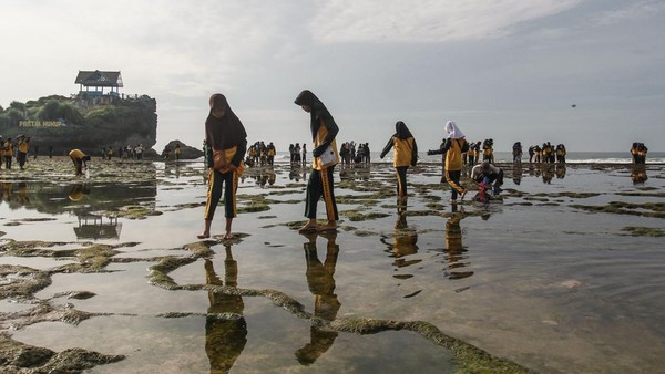 Pengunjung bermain air di Pantai Kukup, Tanjungsari, Gunungkidul, DI Yogyakarta, Minggu (29/1/2023).