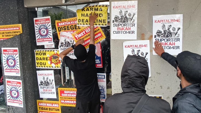 Pengunjuk rasa yang tergabung dalam Arek Malang Bersikap membentangkan spanduk saat berunjuk rasa di depan Kantor Tim Arema FC, Jalan Mayjen Panjaitan, Malang, Jawa Timur, Minggu (29/1/2023). Mereka menuntut manajemen Tim Arema FC agar bertanggung jawab secara moral atas tragedi Kanjuruhan dengan mundur dari kompetisi BRI Liga 1. ANTARA FOTO/Unggul Prabowo/abs/tom.
