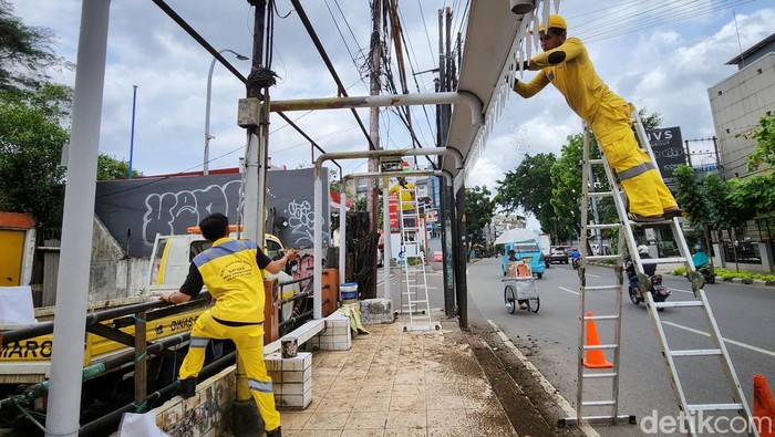 Aksi Petugas Perbaiki Hate Bus Veteran yang Rusak Sejumlah petugas dari Dinas Bina Marga Provinsi DKI Jakarta diterjunkan untuk memperbaiki dengan melakukan pengecatan baru di Halte Veteran, Kebayoran Lama, Jakarta Selatan, Senin (29/01/2022).