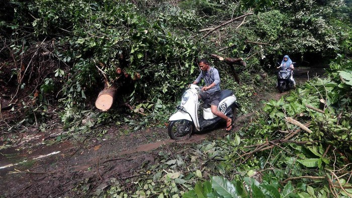 Wisatawan melihat badan jalan yang terputus akibat longsor di jalan kilometer nol, Iboih, Sabang, Aceh, Senin (30/1/2023). Cuaca ekstrem hujan deras yang disertai angin kencang pada 29 Januari 2023 sore, mengakibatkan belasan titik longsor yang memutus akses jalan menuju lokasi wisata Iboih dan puluhan rumah penduduk rusak akibat tertimbun material. ANTARA FOTO / Irwansyah Putra/aww.