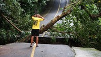 Wisatawan melihat Jalan Kilometer Nol yang putus akibat tanah longsor.
