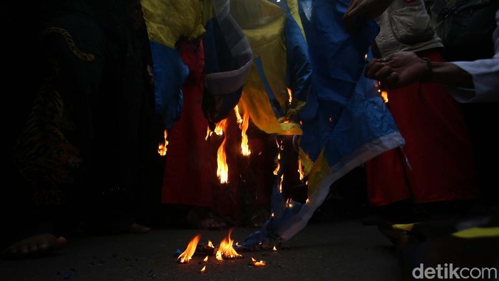 Massa yang berdemo memprotes pembakaran Al-Qur'an oleh Rasmus Paludan di Swedia membakar bendera Swedia. Begini momennya.