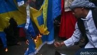 Massa membakar bendera Swedia di depan Kedubes Swedia di Jakarta, Senin (30/1/2023).