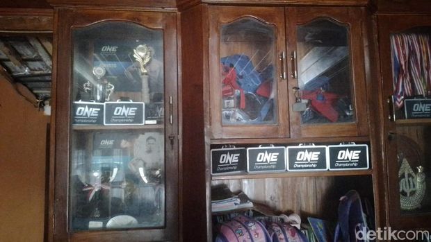 Foto-foto pertandingan Sunoto petarung Mixed Martial Arts (MMA) asal Blora, terpajang di dinding serta sejumlah medali dan sertifikat memenuhi isi lemari. Foto diunggah Senin (30/1/2023).
