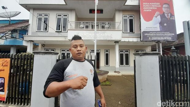 Gaya Asep Sudrajat saat hari libur di depan Kantor Desa Cikaramas, Kecamatan Tanjungmedar, Sumedang, Minggu (29/1/2023).