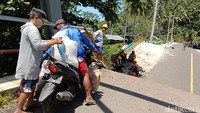 Foto: Pengendara motor hendak mengantar warga melintasi jembatan di Minahasa Utara, Sulawesi Utara yang amblas. (Trisno Mais/detikcom)