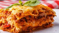 Lasagna, hidangan pasta yang populer. Pasta ini berupa lembaran berbentuk persegi panjang. Setiap lembar pasta ini dilapisi dengan saus, daging cincang, dan keju. Foto: Getty Images/iStockphoto