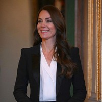 Kate Middleton memadukan blazer hitam Alenxader McQueen dengan blouse putih berlayer dan celana panjang hitam. Foto: Daniel Leal - WPA Pool/Getty Images