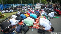 Mereka menggelar salat di jalan, seraya menunggu perwakilan massa menemui kedubes.
