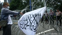 Polisi memasang kawat berduri untuk menghadang massa.