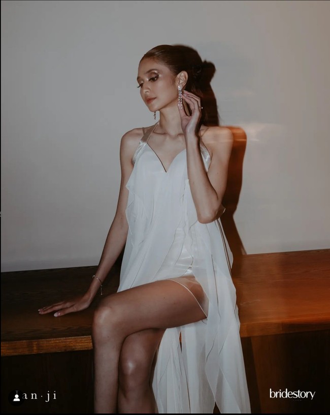 Resepsi malam hari pun berlanjut ke acara pesta. Kali ini Mikha Tambayong tampil seksi dengan gaun asimetris kombinasi bahan satin dan sifon, masih dari rancangan desainer Jeffry Tan. Foto: Instagram/@thebridestory