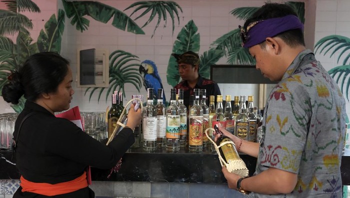 Petugas menata produk arak Bali yang dipamerkan saat perayaan Hari Arak Bali di Bali Collection, Nusa Dua, Badung, Bali, Minggu (29/1/2023). Kegiatan tersebut digelar dalam upaya memperkokoh perlindungan dan pemberdayaan arak Bali sesuai Peraturan Gubernur Bali Nomor 1 Tahun 2020 tentang tata kelola minuman fermentasi dan/atau destilasi khas Bali sebagai tonggak perubahan status yang mengangkat keberadaan, nilai, dan harkat arak Bali yang bertujuan melindungi dan memelihara arak sesuai dengan nilai-nilai budaya serta memberdayakan, memasarkan, dan memanfaatkan minuman tersebut sebagai ekonomi rakyat yang berkelanjutan. ANTARA FOTO/Nyoman Hendra Wibowo/tom.