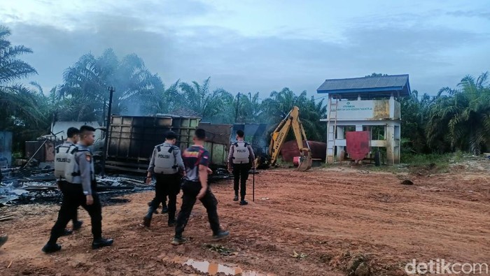 Polisi berjaga di sekitar kantor PT AKG yang diserang massa usai pria yang dituduh mencuri sawit tewas ditembak.