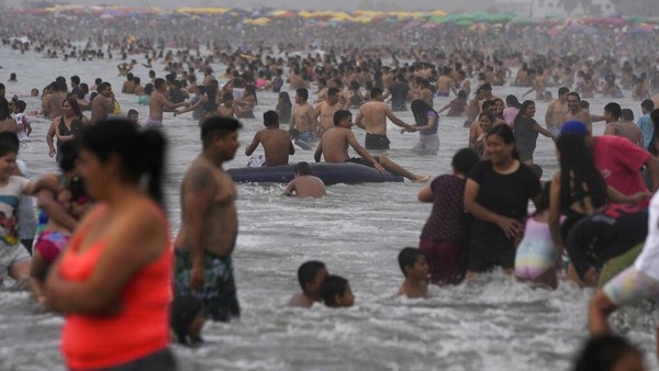 Meski tengah dilanda kekacauan politik, Para warga justru menikmati waktu untuk berlibur dengan berenang ke pantai.