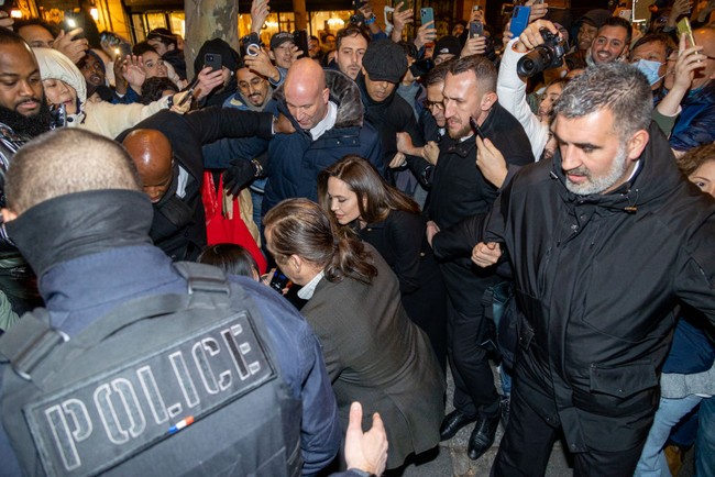 Angelina Jolie mendapat pengawalan ketat saat keluar dari butik Guerlain dan masuk ke dalam mobilnya. Dia kesulitan berjalan karena banyaknya fans yang menyerbunya. Foto: Marc Piasecki/Getty Images for Guerlain