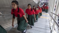 Anak-anak menaiki tangga menuju kereta metro di Dhaka, Bangladesh, Senin (30/1/2023).