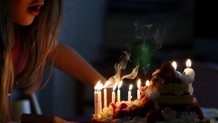 Ilustrasi tiup lilin ulang tahun.
