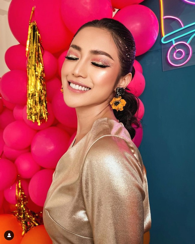 Dengan rambut yang diikat satu ke belakang, Jessica memilih makeup glam dengan eyeshadow glitter yang senada dengan warna bajunya. Untuk mempercantik penampilannya Jessica juga menambahkan aksesori berupa sepasang anting bunga berwarna oranye. Foto: Instagram/@inijedar