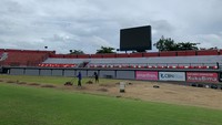Lapangan stadion terlihat dari dalam Bali United Cafe. Petugas sedang memotong rumput lapangan Stadion Kapten I Wayan Dipta. Foto: Siti Muamalah/detikBali